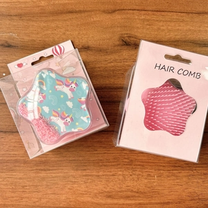 Star-shaped hair comb with unicorn rainbow design and heart sequins in pink packaging
