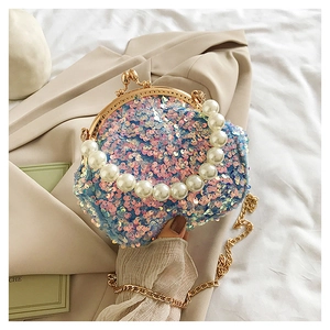 Detail of sequin shell bag with pearl handle and gradient blue-pink finish