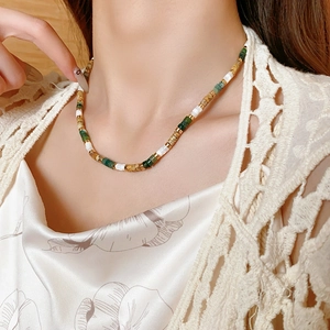 Detailed shot of multi-colored natural stone beaded necklace on a model's neckline