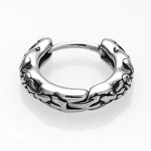 Macro detail of silver stainless steel hoop earring with retro woven texture pattern