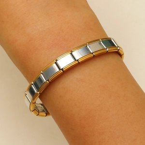 Detail eines zweifarbigen italienischen Gliederarmbands aus Edelstahl in Gold und Silber am Arm
