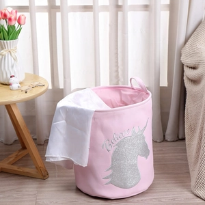 Detail of pink canvas laundry basket featuring silver glitter unicorn and Believe text