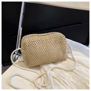 Close-up of woven straw mini square bag with cotton rope strap on white fabric