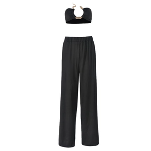 Détail du haut court noir avec boucle en métal doré et pantalon à taille haute