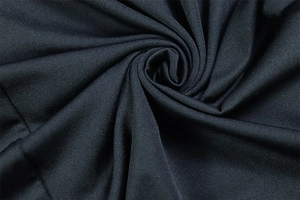 Close-up of black knitted fabric texture with elegant spiral pleated details