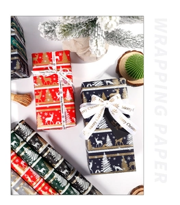 Close-up of festive Christmas wrapping paper rolls with reindeer and snowflake patterns