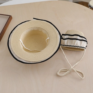 Lace-trimmed children's straw hat and matching crossbody bag set on wooden surface