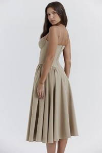 Detail of corset-style beige midi dress featuring thin straps and back zipper closure