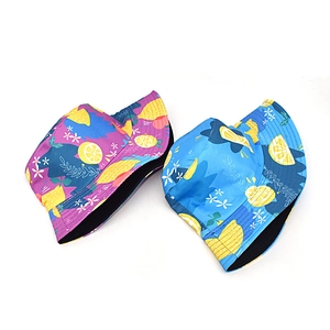 Detail of two reversible bucket hats with yellow lemon and floral patterns on blue and purple