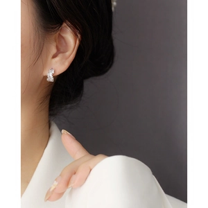 Close-up of elegant S925 silver ear cuff with rectangular zircon on model's ear lobe