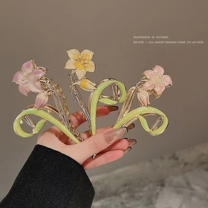 Detailed view of tulip hair claws with enamel flower petals and pearl accents