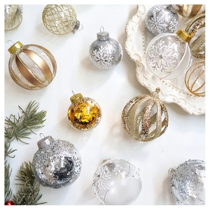 Flat lay of champagne and silver Christmas ball ornaments with intricate textures and glitter