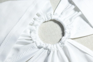 Gros plan d'une robe dos nu blanche avec anneau de connexion et détails de couture plissés