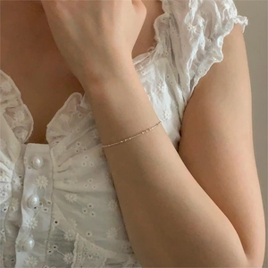 Minimalist 925 sterling silver beaded bracelet in gold finish worn on a wrist
