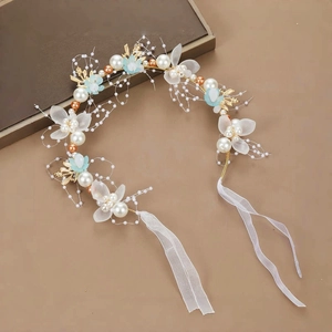 Detail von floralem Haarschmuck mit Perlen, Tüllblüten und elegantem Satinband