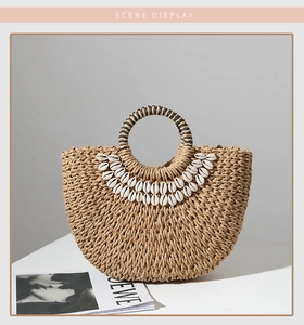 Detailed view of woven straw bag with shell embellishments and striped round handles
