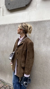 Detail of vintage brown suede blazer jacket featuring lapel collar and flap pockets