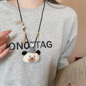 Detail of cute teddy bear pendant necklace with plaid hat, wooden beads and long tassel
