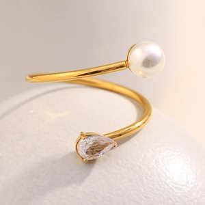 Detailed close-up of 18K gold-plated spiral ring with a white pearl and teardrop zircon