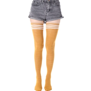 Détail de chaussettes hautes jaune gingembre avec trois rayures blanches et tricot