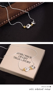 Detailed shot of two-tone snake chain necklace with rings on a premium gift box