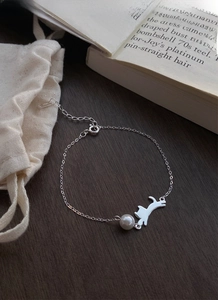 Vista dettagliata del bracciale gatto in argento S925 con perla su fondo in legno vintage