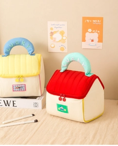 Detail of house-shaped quilted cosmetic bags with lucky embroidery and dual zippers