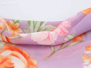 Close-up of floral chiffon fabric with purple base and orange pink blossom pattern