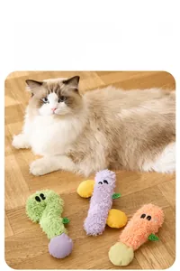 Tre peluche colorati per gatti su pavimento in legno con un gattino Ragdoll