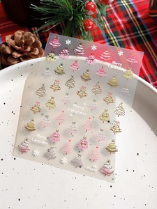 Detail of self-adhesive Christmas tree nail stickers with gold foil and snowflakes