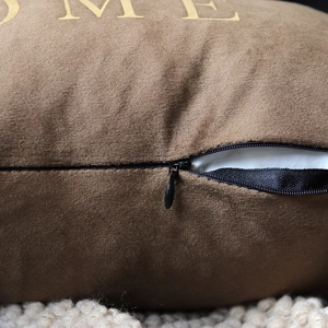 Detailed close-up of brown velvet pillow cover showing invisible zipper and soft texture