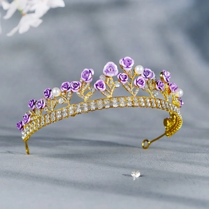 Detailed close-up of bridal tiara with purple handmade roses and white pearls