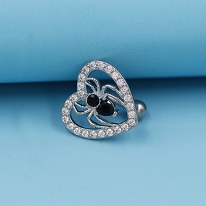 Macro shot of silver heart belly ring with black spider zircon inlay on blue background