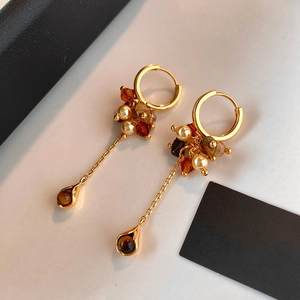 Detail of vintage gold tassel earrings featuring tiger eye stones and white pearls