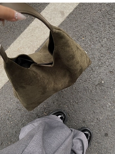 Detail view of olive green frosted hobo bucket bag with a soft suede texture and leather strap