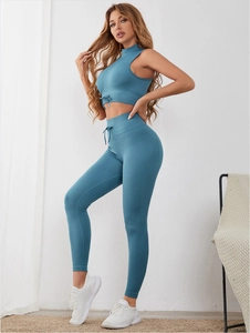 Detail of teal ribbed yoga set showing high-waist leggings and halter top with drawstrings