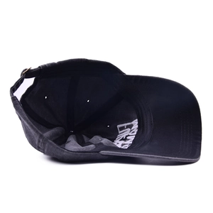 Detail of washed cotton baseball cap showing internal stitching and adjustable metal buckle