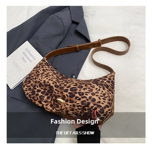 Macro detail of leopard print hobo bag with gold hardware and brown leather strap