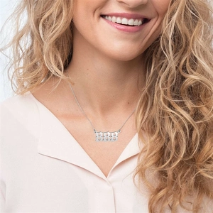 Close-up of a silver stainless steel number necklace worn by a model in bright light