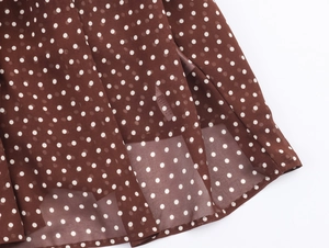 Vista dettagliata dell'orlo della gonna lunga marrone a pois in chiffon con fodera
