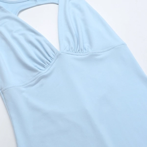 Dettaglio dell'abito allacciato al collo azzurro con scollo a V profondo e trama in maglia