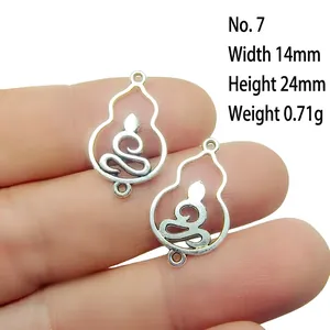 Macro view of silver alloy hollow gourd charms held by hand for DIY jewelry making