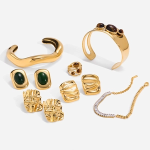 Parure de bijoux en acier doré avec pierres oeil de tigre et oxydes de zirconium sur fond blanc