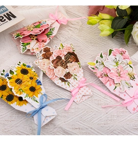 Flat lay of floral greeting cards with 3D bouquets and ribbons on lace fabric