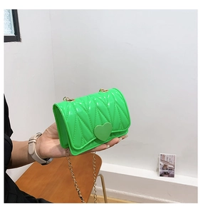 Detail of neon green heart-shaped silicone mini bag with quilted texture and gold chain