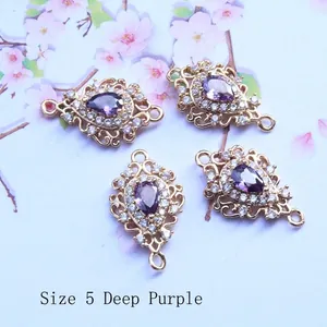 Detailed view of teardrop dark purple gemstones with gold hollow frames for DIY jewelry