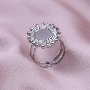 Detailed macro view of silver stainless steel adjustable ring with sunburst pattern disc