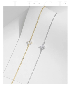 Detail of silver and gold four-leaf clover bracelets with sparkling zircon pavé