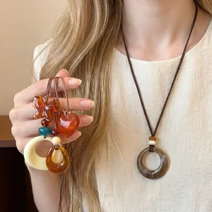 Retro resin pendant necklaces featuring geometric shapes and amber butterfly on brown cords