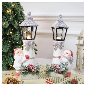 Detail of ceramic Santa and Snowman Christmas lighthouses with warm LED light and snow texture